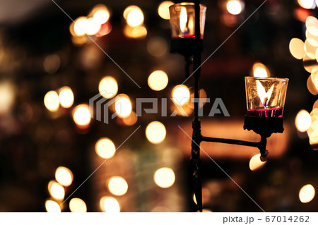 A Burning Candle in Clear Glass stick with steel rod Decorated in Hotel, Restaurant or Home. Selective Focus, Blurred Background with Bokeh. A Burning Candle in Clear Glass stick with steel rod Decorated in Hotel, Restaurant or Home. Selective Focus, Blurred Background with Bokeh. 67014262