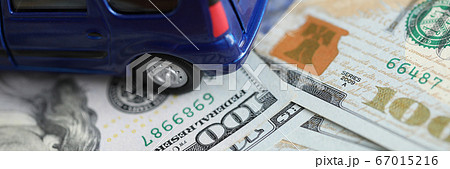 Blue toy minivan car costs on scattered dollars 67015216