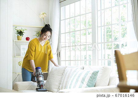 ソファーを掃除する若い女性 ソファーを掃除する若い女性 67016146