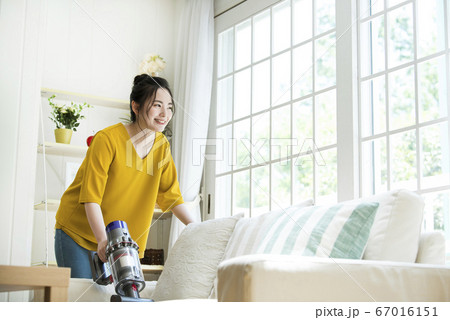ソファーを掃除する若い女性 67016151