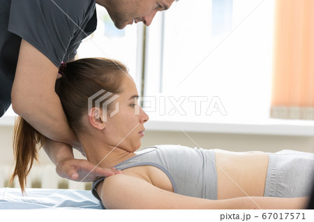 Osteopath treatment - the medical master holding the neck and leans on shoulders of young woman Osteopath treatment - the medical master holding the neck and leans on shoulders of young woman 67017571