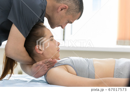 Osteopath treatment - the medical master holding the neck of young woman Osteopath treatment - the medical master holding the neck of young woman 67017573