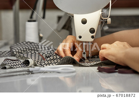 girl seamstress sew on the sewing machine 67018872