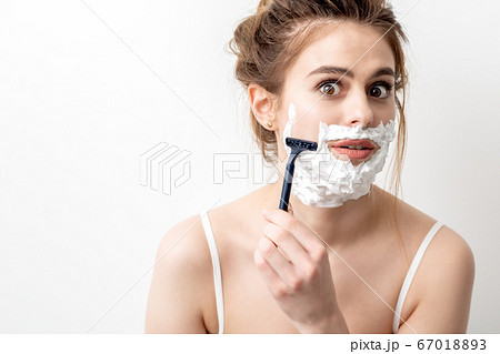 Woman shaving her face by razor 67018893
