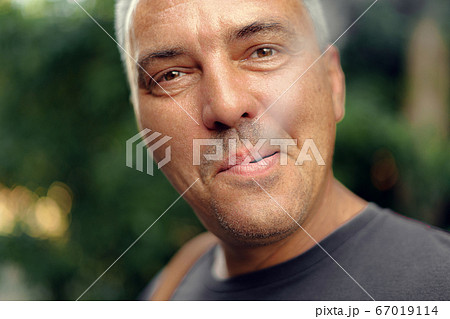 Caucasian mature middle aged man smoking cigarette outdoors. Nicotine addiction. Copy space Caucasian mature middle aged man smoking cigarette outdoors. Nicotine addiction. Copy space 67019114