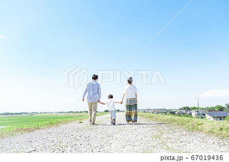 家族 青空 散歩 後ろ姿の写真素材