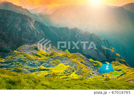 Wonderful glacier lake and mountain ridge at sunset, Romania 67019765