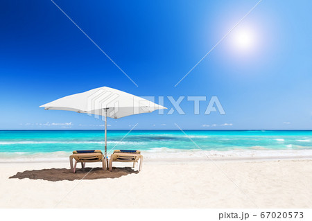 Beach chairs with umbrella and beautiful sand 67020573