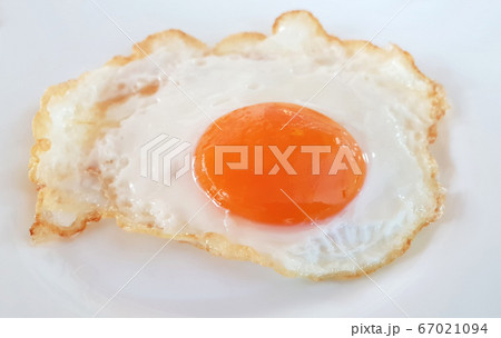 Fried egg on a white plate Fried egg on a white plate 67021094