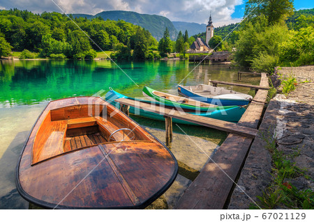 Spectacular alpine lake and colorful canoes, Lake Bohinj, Slovenia, Europe Spectacular alpine lake and colorful canoes, Lake Bohinj, Slovenia, Europe 67021129