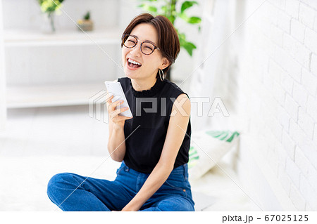 女性　スマホ　胡座　家 67025125