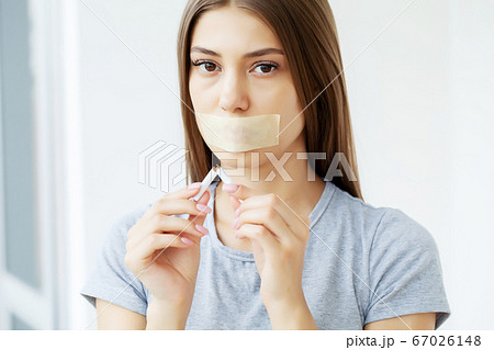 Stop smoking, a young woman with a sealed mouth draws attention to the harmful effects of smoking on health 67026148