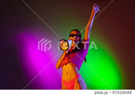 Beautiful seductive girl in fashionable swimsuit on disco bicolored neon studio background in neon light. Summer, resort, fashion and weekend concept Beautiful seductive girl in fashionable swimsuit on disco bicolored neon studio background in neon light. Summer, resort, fashion and weekend concept 67028088