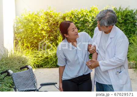The doctor is helping to lift the patient out of The doctor is helping to lift the patient out of 67029571