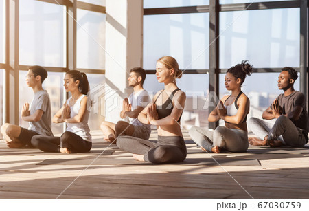 Meditation Session. Group Of Diverse Sporty People Practicing Yoga In Modern Gym Meditation Session. Group Of Diverse Sporty People Practicing Yoga In Modern Gym 67030759