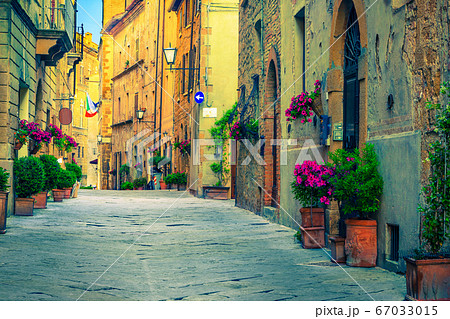 Brick and stone houses decorated with colorful flowers, Pienza, Italy Brick and stone houses decorated with colorful flowers, Pienza, Italy 67033015