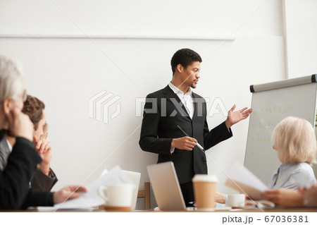 Black coach giving presentation to employees at conference group 67036381