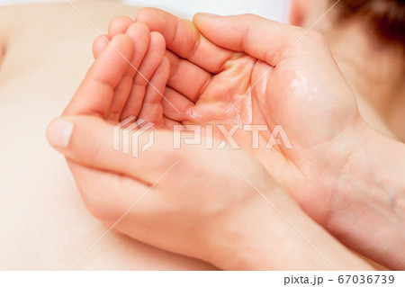 Massage oil in palms of massager. 67036739