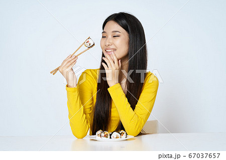 Woman in yellow sweater diet sushi rolls tradition 67037657
