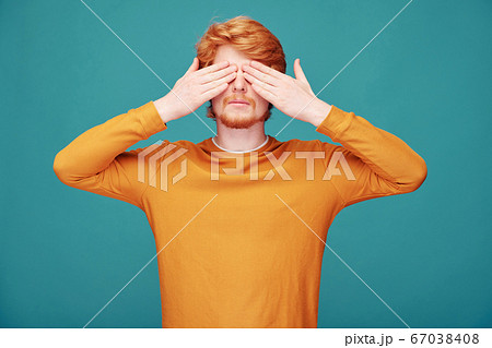 Redhead man closing eyes with hands Redhead man closing eyes with hands 67038408