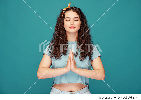 Calm girl meditating with closed eyes 67038427