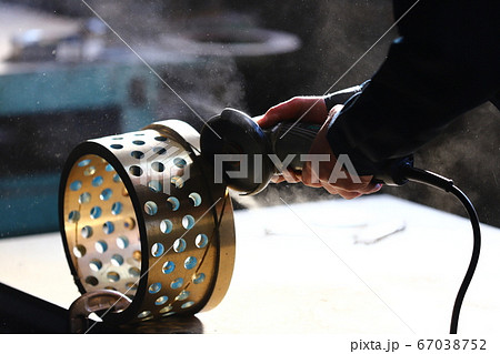 グラインダーで部品の切断作業 67038752