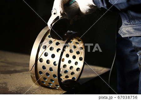 グラインダーで部品の切断作業 67038756