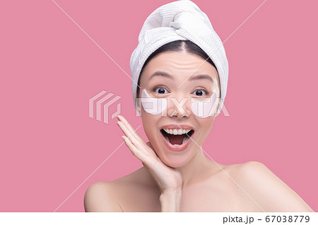 Woman using eye-patches during everyday skincare procedure 67038779