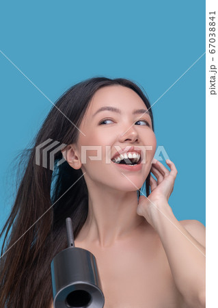 Happy woman drying her long dark hair 67038841