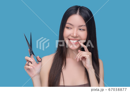 Smiling young long-haired woman thinking about haircut 67038877