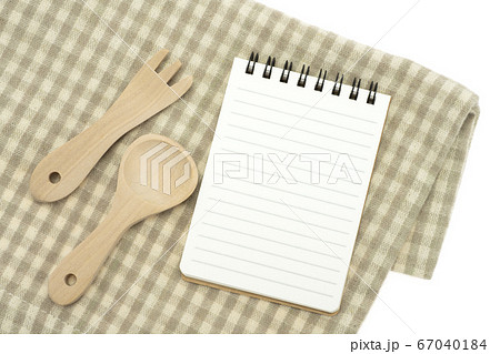 ランチョンマットの上に置いたメモ帳とフォークとスプーン 67040184