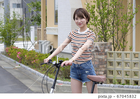 住宅街で自転車を乗る女性 67045832