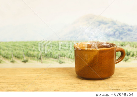 a cup of coffee on wood in the coffee plantation a cup of coffee on wood in the coffee plantation 67049554