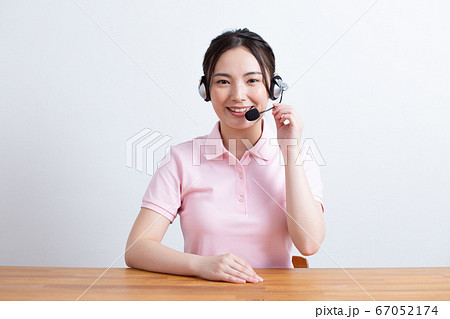 ヘッドセットを着けてカメラ目線で話す女性 ヘッドセットを着けてカメラ目線で話す女性 67052174