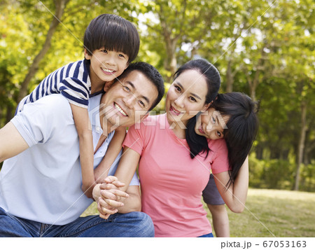 outdoor portrait of a happy asian family with two children 67053163