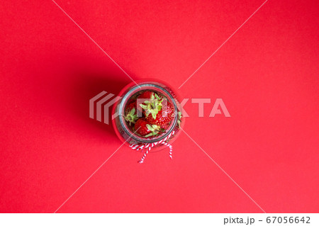Flatlay composition on a glass jar on a red 67056642