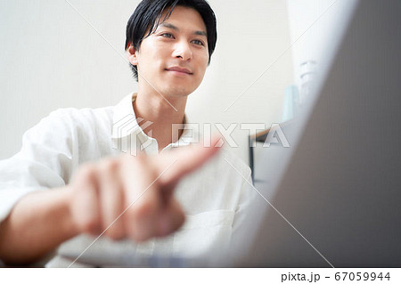 パソコンの起動ボタンを押す男性 パソコンの起動ボタンを押す男性 67059944