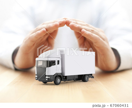 White cargo delivery truck miniature protected by hands 67060431
