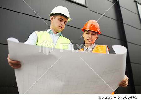 Examining the blueprint of new building Examining the blueprint of new building 67060445