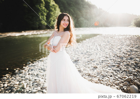 Beauty portrait of bride wearing fashion wedding dress with feathers with luxury delight make-up and hairstyle Beauty portrait of bride wearing fashion wedding dress with feathers with luxury delight make-up and hairstyle 67062219