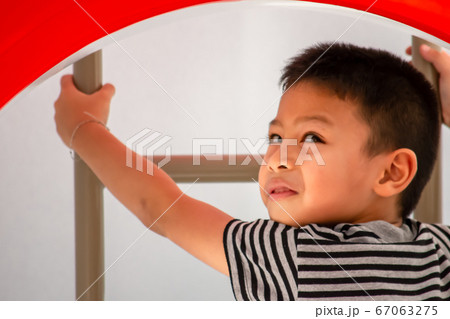 Portrait of Asian boys are climbing the ladder in the playground. Portrait of Asian boys are climbing the ladder in the playground. 67063275