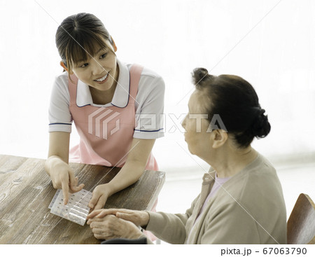 薬ケースの説明をする介護士 薬ケースの説明をする介護士 67063790