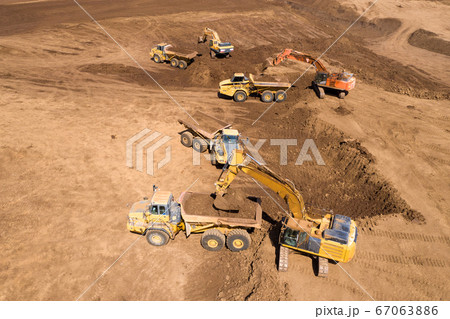 Excavator loading soil onto an Articulated hauler Truck 67063886