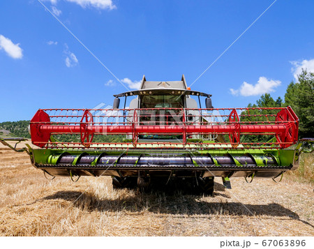 Combine harvester parked in a large Wheat field. Combine harvester parked in a large Wheat field. 67063896
