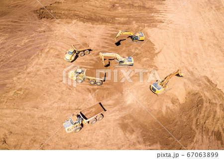Excavator loading soil onto an Articulated hauler Truck 67063899