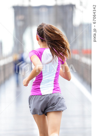 City runner - woman running on Brooklyn Bridge 67064342