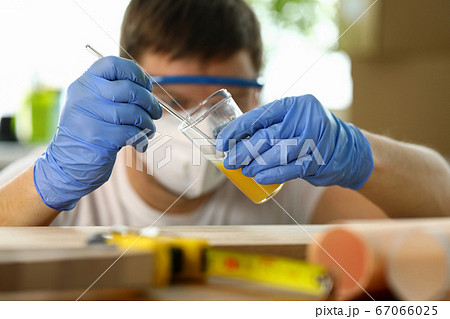 Male carpenter applying varnish on wooden surface 67066025