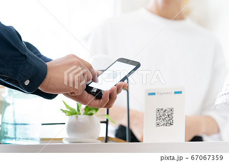 スマホでキャッシュレス決済をする男性【QRコード】 67067359