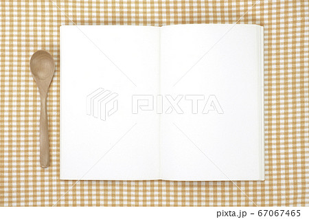 ランチョンマットの上に置いたスケッチブックとスプーン 67067465