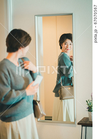 外出前の鏡チェックをする30代女性 外出前の鏡チェックをする30代女性 67070567
